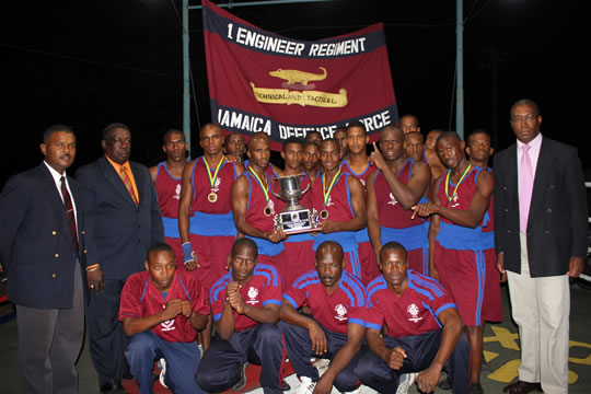 Members of the Force Boxing Champions 1 Engineer Regiment (JDF) team pose with their trophy as they are flanked by Captain Lloyd, Regimental Sergeant Major WO1 Smith (left) and Commanding Officer Lieutenant Colonel Cummings (right).
Photo credit: LCpl Darren Beckles